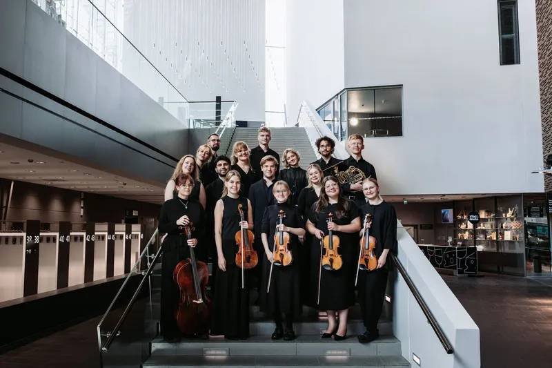 Academy musicians with their instruments on the stairs at Musiikkitalo